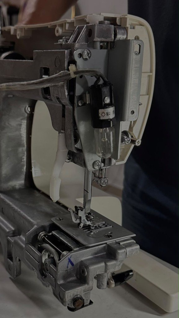 Aguja y prensatelas de una máquina de coser en reparación en GALO Atelier, El Salvador
